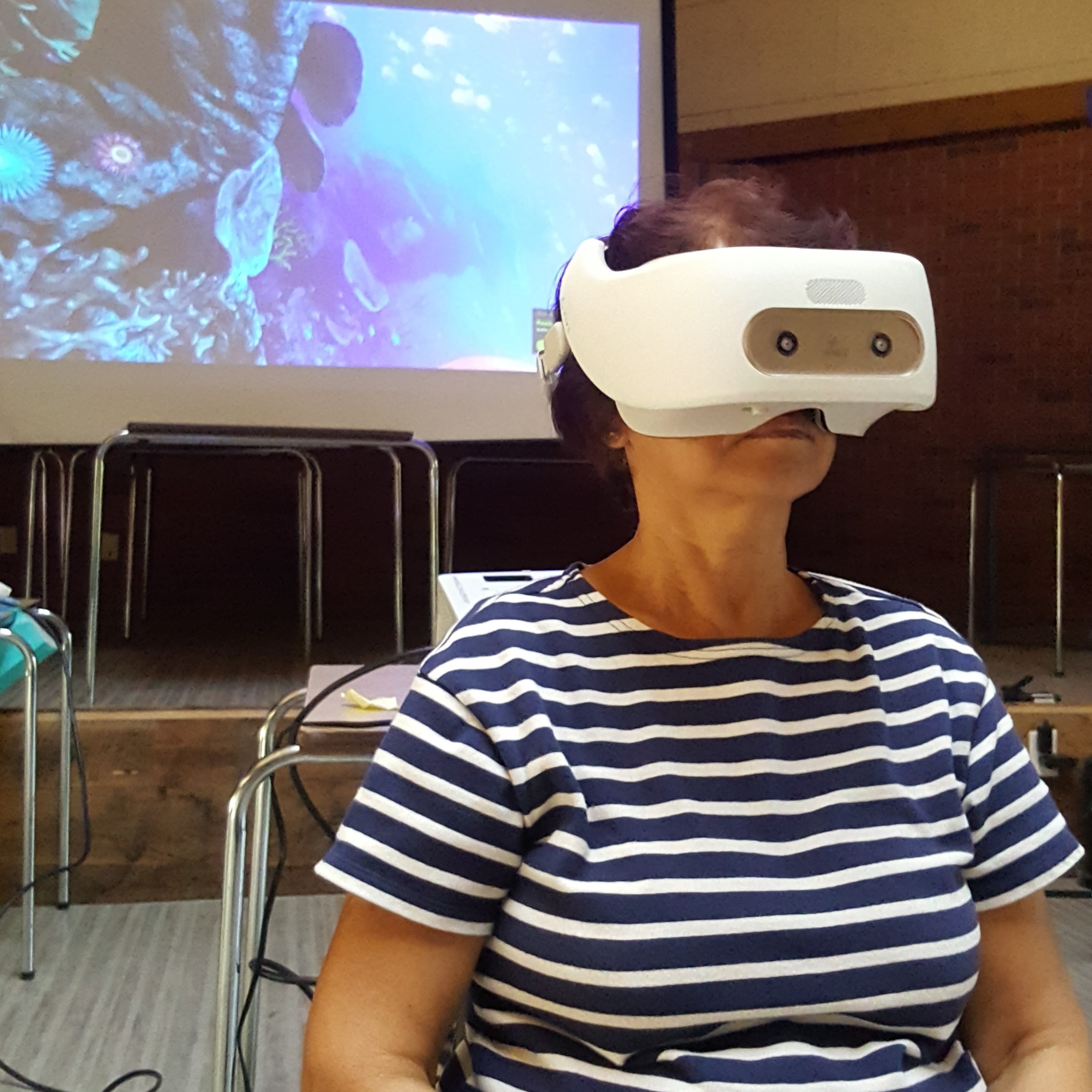 An older lady viewing virtual reality in a HTC Vive Focus.
