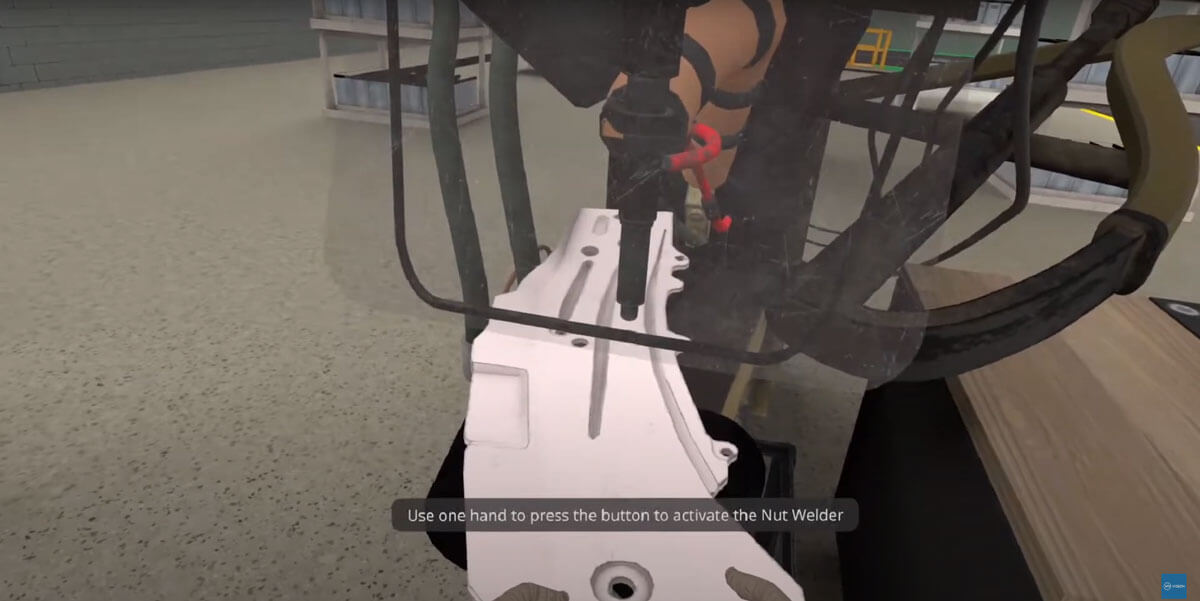 Trainee's hands near a pinch point on a machine inside a VR manufacturing safety simulation